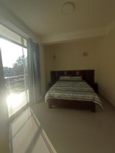 a bedroom with a bed and a large window at Apartments in Chiclayo