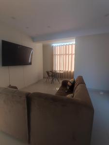 a living room with a couch and a flat screen tv at Apartments in Chiclayo