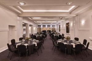 um salão de banquetes com mesas e cadeiras numa sala em The Victoria Hotel em Melbourne