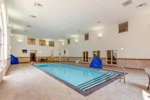ein großer Pool in einem großen Zimmer mit einem Tisch und Stühlen in der Unterkunft Comfort Inn & Suites in Rapid City