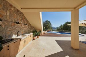 uma cozinha com uma parede de pedra e uma piscina em Luxuriöse Villa mit Pool nahe Canyamel em Capdepera