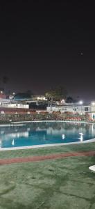 a large swimming pool at night with tables and chairs at Relax in pasito blanco camping house in Maspalomas