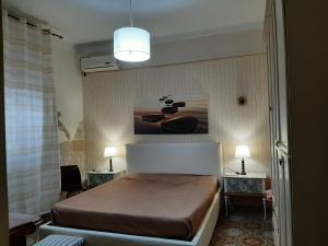 1 dormitorio con 1 cama y una pintura en la pared en Villa Gisella, en Punta Prosciutto