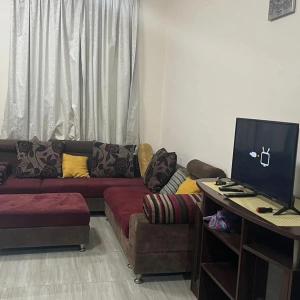 a living room with a couch and a desk with a computer at The great house in Dubai