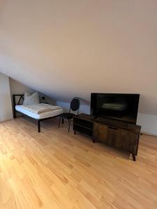 a room with a bed and a flat screen tv at Ferienwohnung Aspelohe - Apartment 1 in Norderstedt