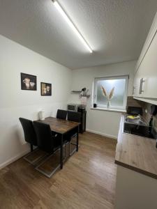 eine Küche und ein Esszimmer mit einem Tisch und Stühlen in der Unterkunft Ferienwohnung Aspelohe - Apartment 1 in Norderstedt