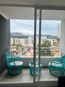 a balcony with chairs and a table and a window at Departamento Reñaca alto in Viña del Mar