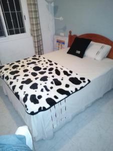 uma cama com um cobertor preto e branco em EL MAR BEACH em Moulay Bousselham