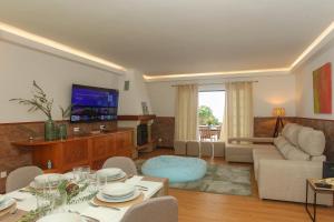 un soggiorno con un divano e una TV di Capelas Blue , Relax & Fun - Up to 14 Guests! a Ponta Delgada