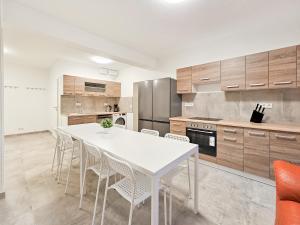een keuken met een witte tafel en stoelen bij RAJ Living - 3 , 4 and 5 Room Apartments - 20 Min zur Messe DUS in Willich