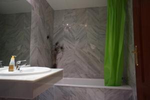 a bathroom with a sink and a green shower curtain at Cute and relaxing bed and breakfast en Albayzín in Granada