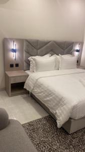 Un dormitorio con una cama grande con una cruz. en جادا للشقق المخدومة Jada en Al Khobar