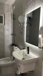 a bathroom with a sink and a toilet and a mirror at جادا للشقق المخدومة Jada in Al Khobar