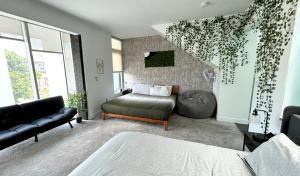 een woonkamer met een bank en een bed bij Tokyo in Denver, Speakeasy Room & Skyline Rooftop In Central RiNO in Denver