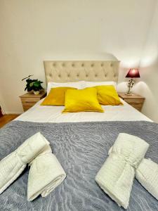 a bedroom with a bed with yellow pillows at NewDay Property - Chelsea in London