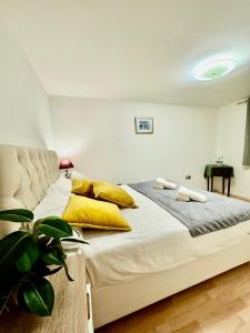 a bedroom with a large bed with yellow pillows at NewDay Property - Chelsea in London
