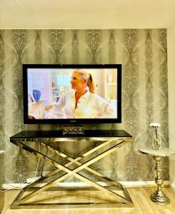a flat screen tv on a stand in a living room at NewDay Property - Chelsea in London