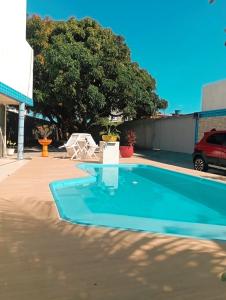uma piscina num parque de estacionamento ao lado de um edifício em Pousada Carvalhos - Camaçari em Camaçari