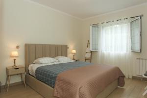 a bedroom with a large bed and a window at Capelas Blue , Relax & Fun - Up to 14 Guests! in Ponta Delgada
