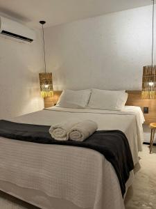Un dormitorio con una cama blanca con toallas. en Villas Patacho Dreams en Pôrto de Pedras