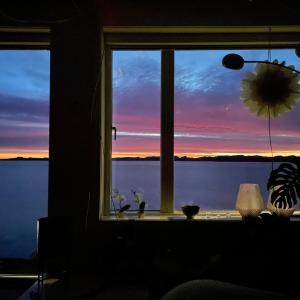 a window with a view of a sunset at The White House in Nuuk