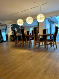 a dining room with a table and chairs and lights at The White House in Nuuk