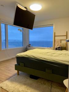a bedroom with a large bed with a large window at The White House in Nuuk
