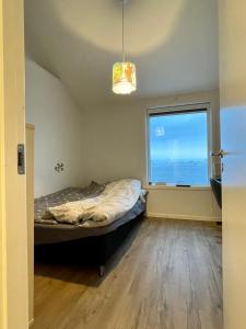 an empty room with a bed and a window at The White House in Nuuk