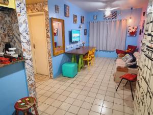 uma sala de estar com paredes azuis e uma mesa e cadeiras em Apê Espaçoso e Econômico - Pertinho da Praia no Recife