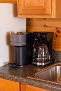 a coffee maker sitting on top of a kitchen counter at Nantahala Resort cabin, POOL OPEN, horseback riding, game room, gym, restaurant on site in Bryson City