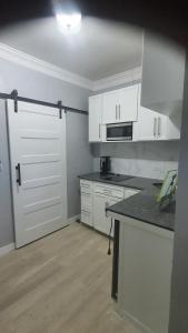 a kitchen with white cabinets and a white door at Kozy Bahamas Getaway in Nassau