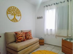 una sala de estar con sofá y una foto de árbol en la pared en Bate & Volta - Apartamentos com 2 quartos próximo ao SESC Bertioga, en Bertioga