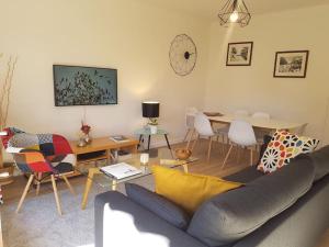 un salon avec un canapé et une table dans l'établissement le Nid des Cèdres, voisin des Thermes et du centre, à Thonon-les-Bains 5 autres photos