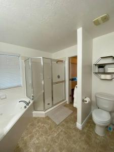 uma casa de banho com um WC, um chuveiro e um lavatório. em Snug Home with fenced yard em West Valley City
