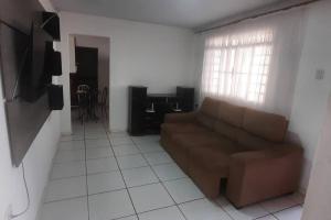 a living room with a couch and a tv at Casa dos Sonhos in Campo Grande