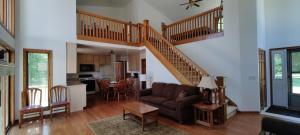 a living room with a couch and a staircase at Adventures @ Cottage on the Bend in Leota