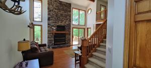 a living room with a staircase and a fireplace at Adventures @ Cottage on the Bend in Leota