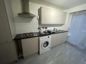 a kitchen with a washer and a washing machine at Bowman’s Place Cosy Lodge in Kent
