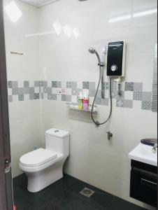 bagno con servizi igienici e doccia. di Homey Stopover Cherating a Kuantan