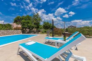 una piscina con 2 tumbonas y una mesa azul en Apartments with a swimming pool Zgaljici, Krk - 21703, en Malinska