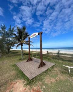 um calçadão de madeira na praia com uma palmeira em Pousada Baía do Sol Vilatur em Saquarema