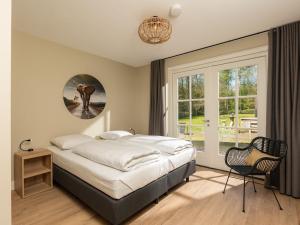Un dormitorio con una cama grande y una ventana en Luxury group accommodation with hot tub and Finnish kota, located in Twente, en Losser