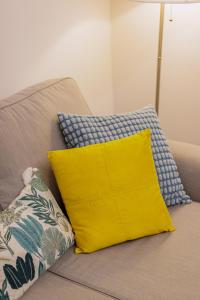 a yellow pillow sitting on top of a couch at Feltrinelli Suite in Modena