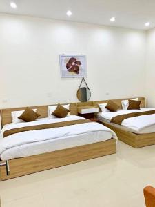 2 camas en un dormitorio con paredes blancas en GREEN HOTEL, en Cao Bằng