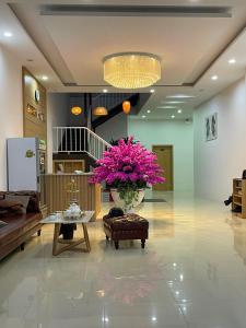 a lobby with a vase of pink flowers on a table at Green Hotel Cao Bằng in Cao Bằng