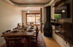 uma sala de jantar com uma mesa longa e uma lareira em LOCAR-IN GRAMADO - Duplex Solar da Borges em Gramado