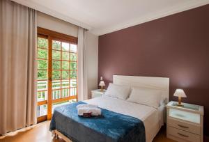 una camera con un letto e una grande finestra di LOCAR-IN GRAMADO - Duplex Solar da Borges a Gramado