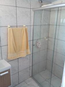 uma casa de banho com um chuveiro e uma toalha amarela em Casa SFX Centro em São José dos Campos