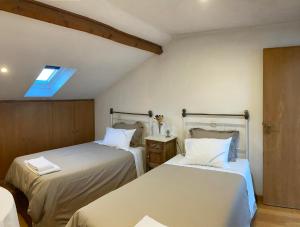 アロウカにあるA Avozinha - Aroucaのベッドルーム1室(ベッド2台、天窓付)