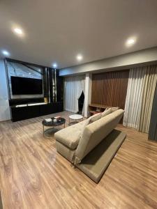 uma sala de estar com um sofá e uma televisão de ecrã plano em Cozy condo lake view 15th floor em León